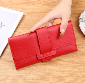Detail of red leather long wallet for women with textured lychee grain and flap closure