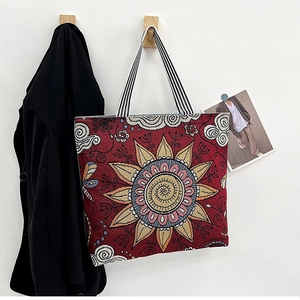 Detail of vintage canvas tote with mandala sun print and striped woven handles