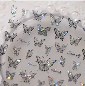 Gros plan de stickers à ongles papillon holographiques avec des lignes noires fines