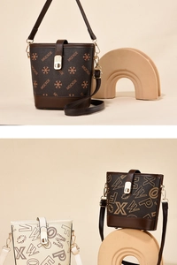 Detail view of printed bucket bags with adjustable straps and golden metal buckles