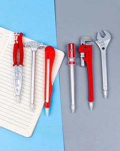 Close-up of six creative hardware tool shaped ballpoint pens on a notebook surface