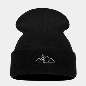 Close-up of black ribbed knit beanie featuring minimalist white mountain embroidery detail
