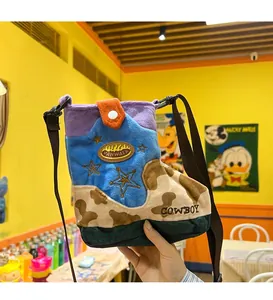 Close-up of a whimsical boot-shaped nylon bag with cow print and colorful embroidery