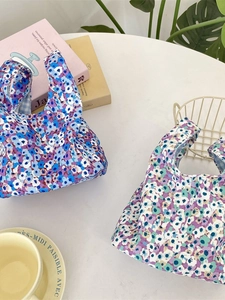 Floral corduroy wristlet bags in two colors shown in a cozy lifestyle setting