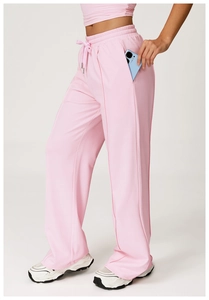 Detail of high-waist light pink sweatpants showing drawstring waist and deep side pockets