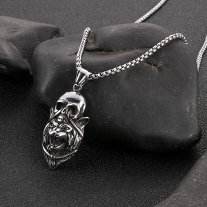 Macro shot of silver skull and wolf pendant on a wet stone for gothic style
