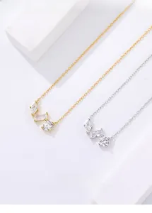 Macro view of gold and silver necklaces featuring sparkling marquise and round zircon pendants