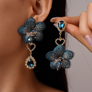 Détail de boucles d'oreilles fleurs en tissu vintage avec cristaux et pendentif goutte