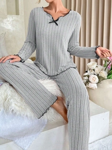 Detailed view of grey ribbed fabric loungewear with lettuce trim and black bow decoration