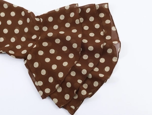 Détail des manches à volants multicouches en mousseline marron à pois blancs