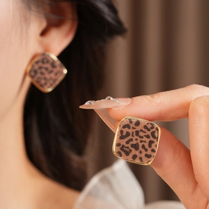 Détail de la boucle d'oreille carrée à motif léopard avec bordure dorée luxueuse