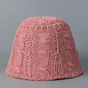 Détail d'un chapeau cloche rose tricoté montrant les torsades et motifs ajourés