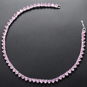 Close-up of pink heart-shaped crystal necklace in silver setting with detail view