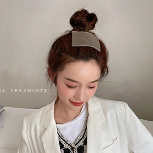 Elegant khaki hair velcro pad for styling baby hairs on a model with white suit