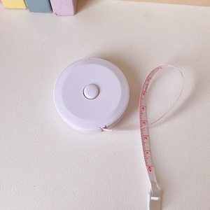 Detail view of a 150cm mini retractable measuring tape with red scales on white tape