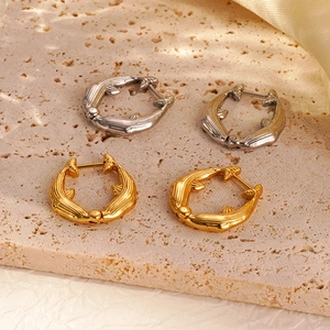 Close-up of polished dolphin-shaped hoop earrings in gold and silver finishes