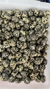 Macro view of multiple 15mm heart-shaped marble stones with black spotted patterns