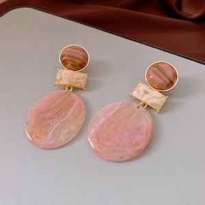 Detail of pink and brown resin geometric earrings with elegant gold metallic borders