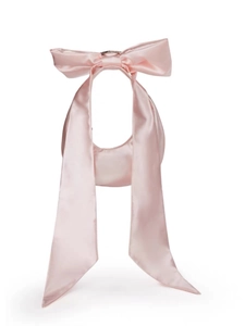 Dettaglio del fiocco di raso rosa con nastro lungo e consistenza elegante sulla borsa a spalla