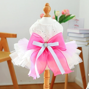 Close-up of pet wedding dress with lace bodice, white tutu skirt and large pink bow