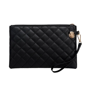 Classic black quilted clutch bag with gold zipper and wristlet on white background