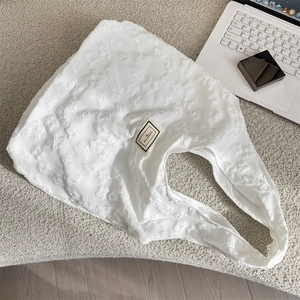 Close-up of white jacquard tote bag with 3D butterfly texture and Pleasant Time patch