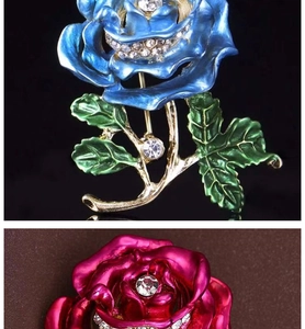 Close-up of enamel rose brooches with blue and pink petals and crystal details