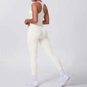 Detail view of ivory white racerback yoga top and high-waist leggings from a 45-degree back angle