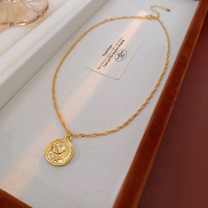 Close-up of golden coin pendant with moon and star relief in elegant jewelry box