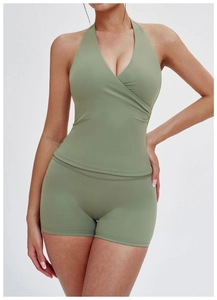 Front view of V-neck sage green yoga set showing cross neck design and slim shorts