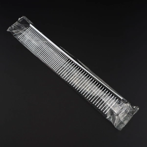 Macro view of silver stainless steel pet grooming comb with dense metal teeth in packaging