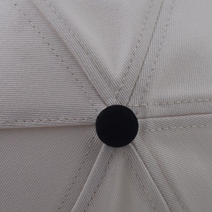 Gros plan de la couronne de la casquette montrant la texture en coton et le bouton