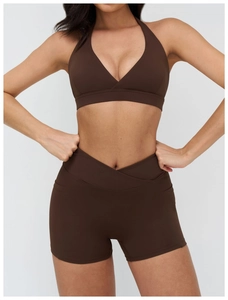 Dettaglio degli shorts da yoga con vita a incrocio e reggiseno sportivo marrone