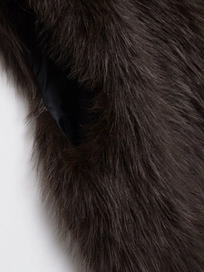 Detailed close-up of dark brown faux fur vest showing dense texture and soft synthetic hair