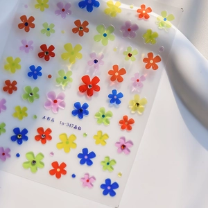 Detail of colorful five-petal flower nail stickers with crystal rhinestones on white background