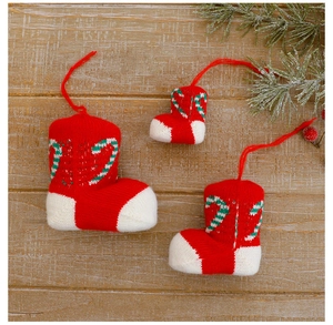 Three red and white knitted Christmas stockings with candy cane patterns on wood