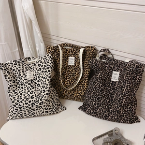 Detailed macro view of leopard print canvas tote bags in three colors with woven label
