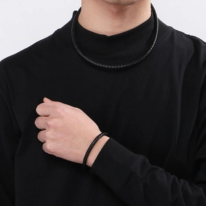 Gros plan sur l'ensemble collier et bracelet tressé noir avec fermoir magnétique en acier