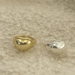 Close-up of gold and silver heart rings with beaded edges on a soft fleece background