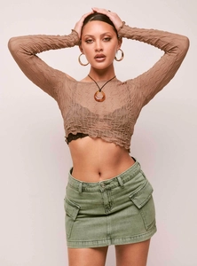 Détail de mini-jupe cargo en jean vert olive avec poches et haut plissé marron chic