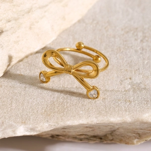 Macro shot of 18k gold stainless steel bow ring with heart cubic zirconia stones