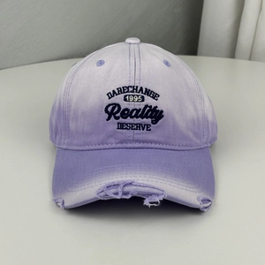 Detail of distressed brim and embroidery on a vintage lavender cotton baseball cap