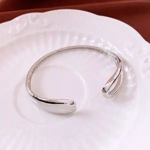 Minimalist silver plated open cuff bracelet with a polished mirror finish on white ceramic
