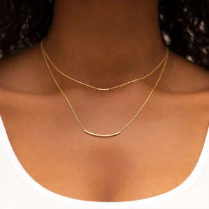 Detail einer S925 Silberkette mit Goldstab-Anhänger und kleinen Perlen im Lagenlook