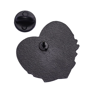 Detail view of the heart-shaped metal pin back with a black rubber butterfly clutch
