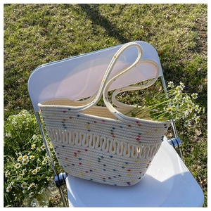 Detailed texture of hand-woven straw tote bag with colorful dots for summer beach vacation