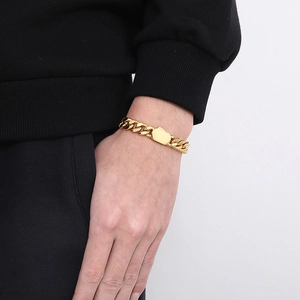 Close-up of a gold Cuban link bracelet featuring a polished rectangular clasp on wrist