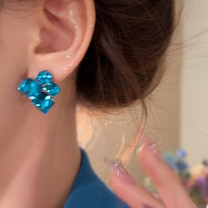 Close-up of blue geometric crystal square earrings worn by a model for a stylish look