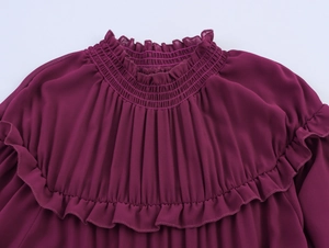 Détail du col montant smocké et des volants sur une robe en mousseline violette