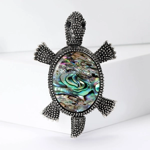Vintage silver turtle brooch with colorful abalone shell shell on a clean background